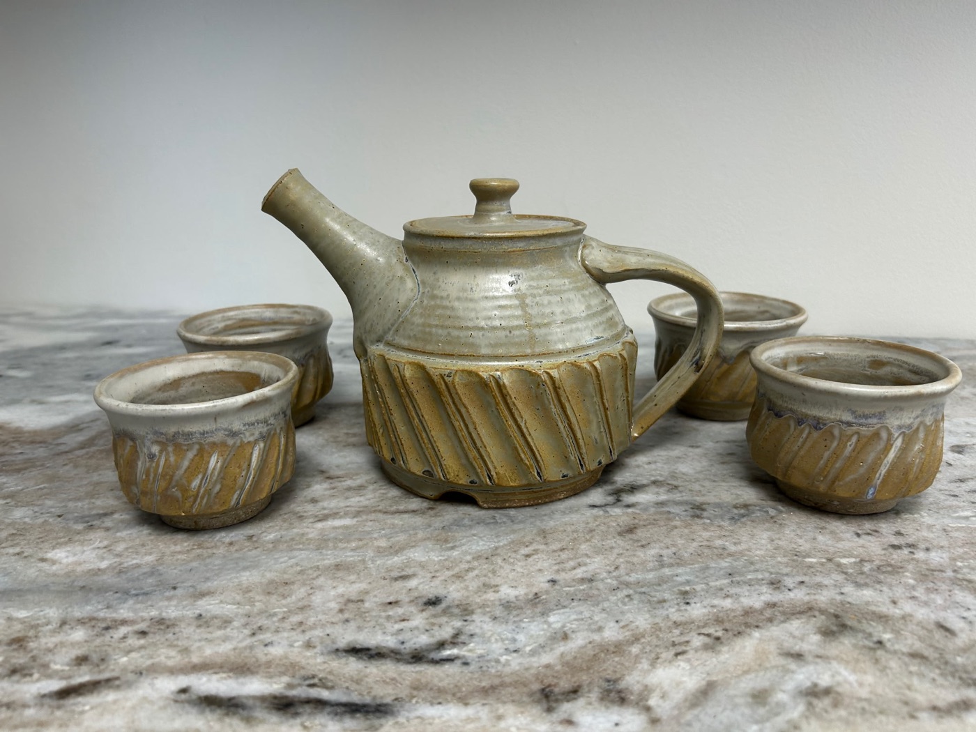 Handmade cream and honey faceted stoneware teapot with four matching carved cups