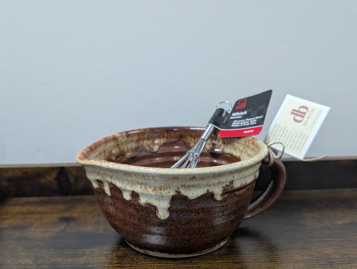 Handmade pottery batter bowl with rust body, dripping cream rim, and loop handle
