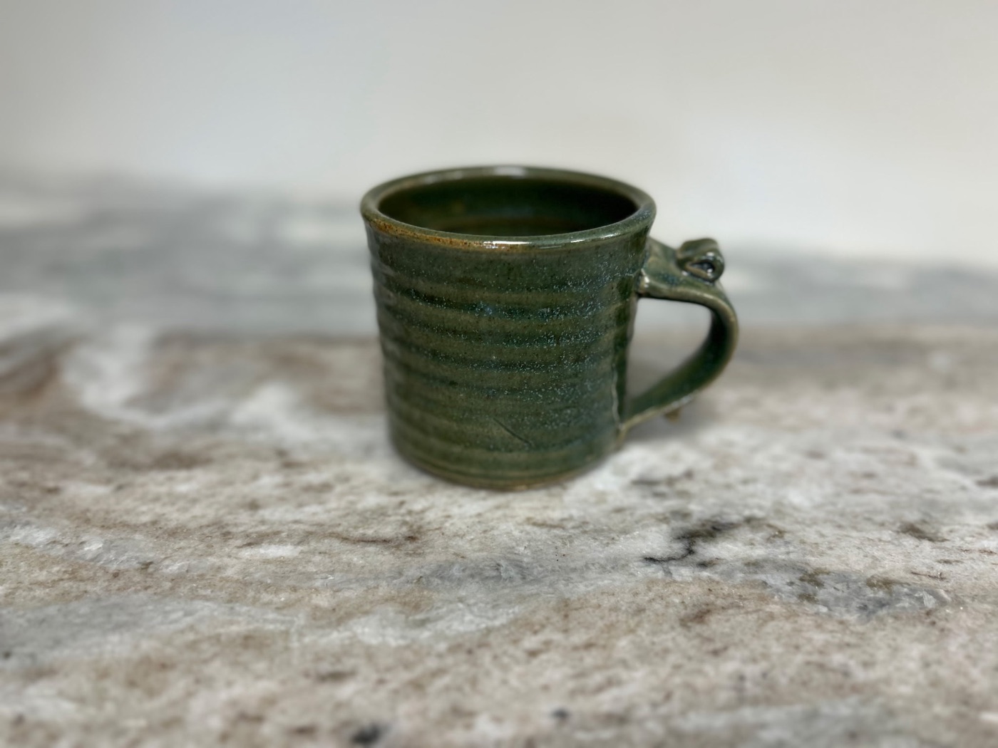 Handmade forest green pottery mug with horizontal throwing ridges