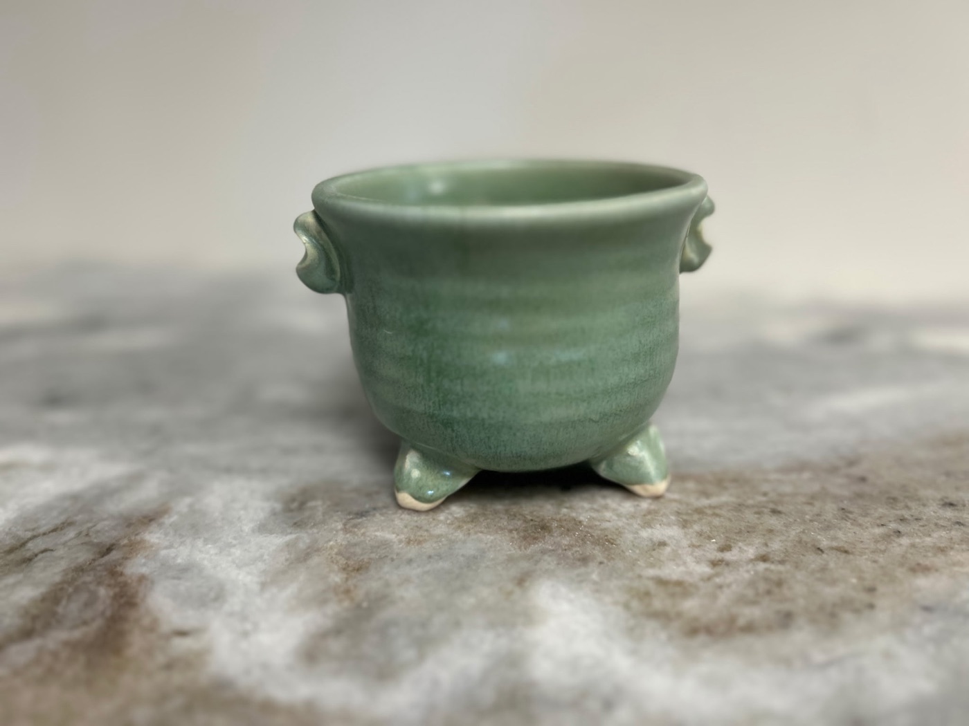 Handmade soft mint celadon stem bowl with three feet and two ear handles, for cut flowers