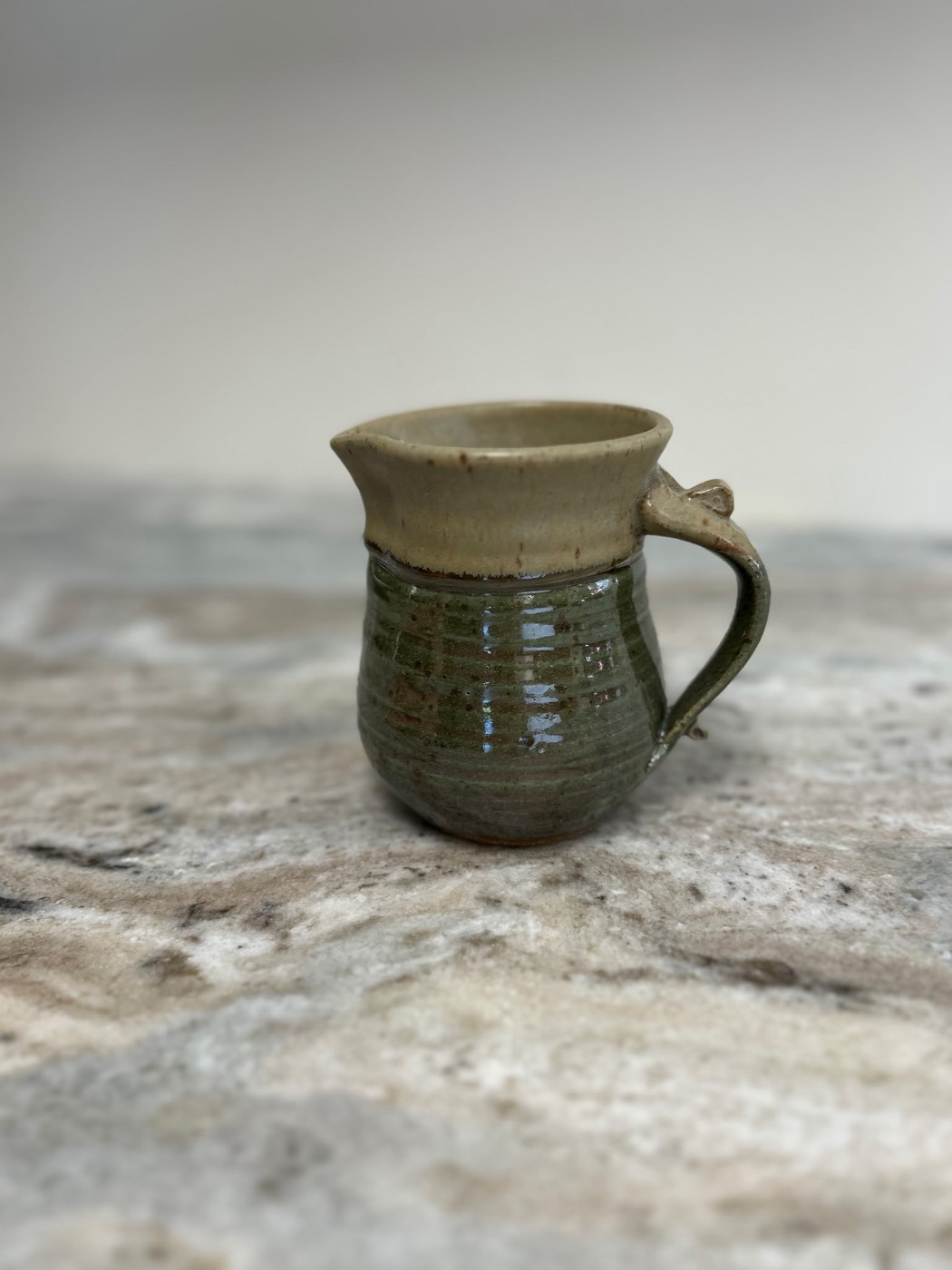 Handmade small pottery pitcher with cream rim and sage green body