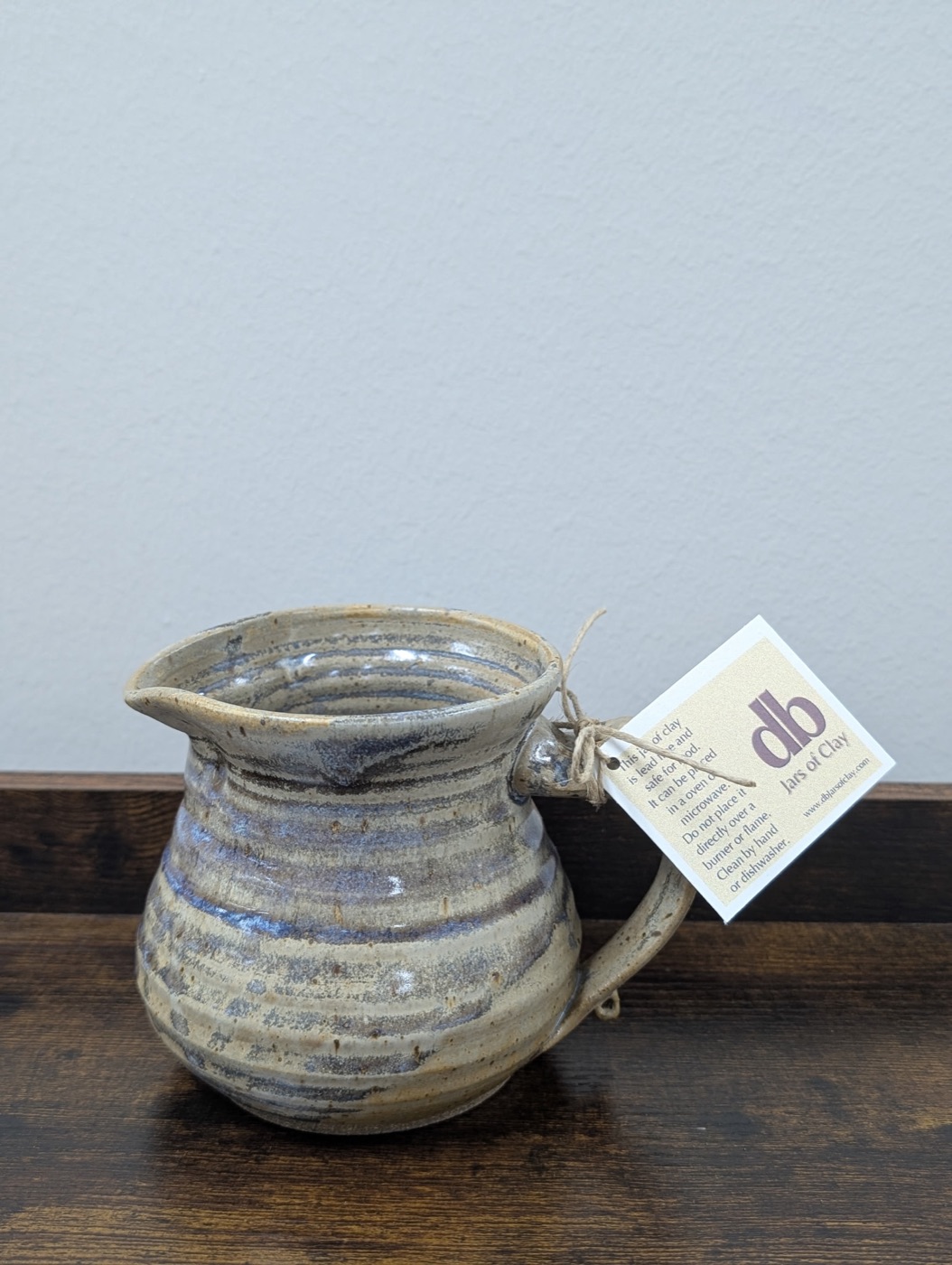 Handmade pottery pitcher with carved ribs in cream and slate blue