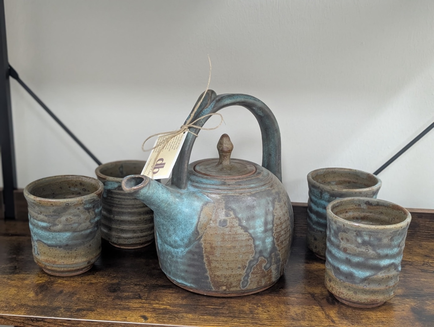 Handmade stoneware teapot with four matching cups in blue and rust drip glaze, made in Little Rock