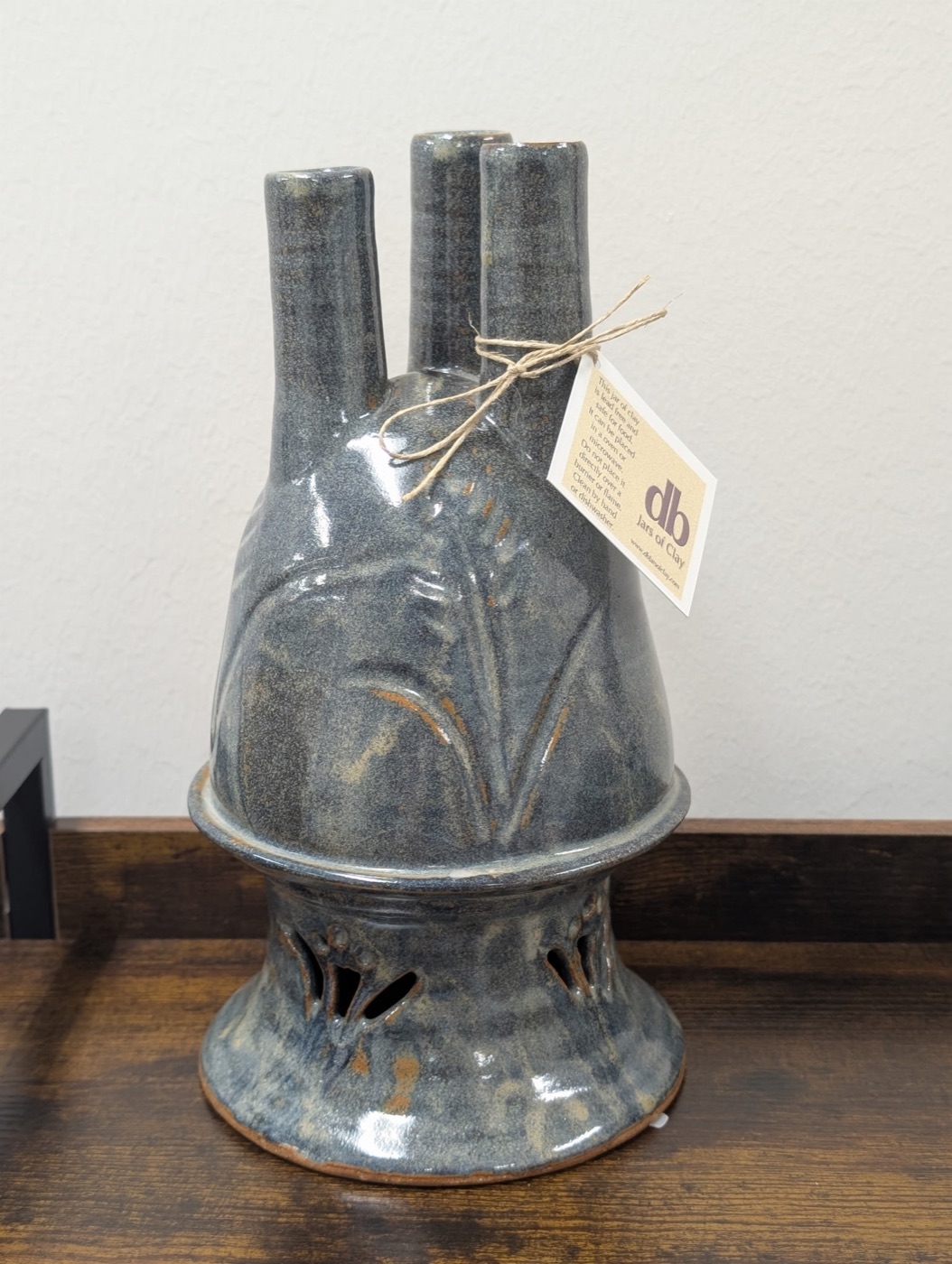 Handmade slate blue three-spout pottery vase with carved iris motif